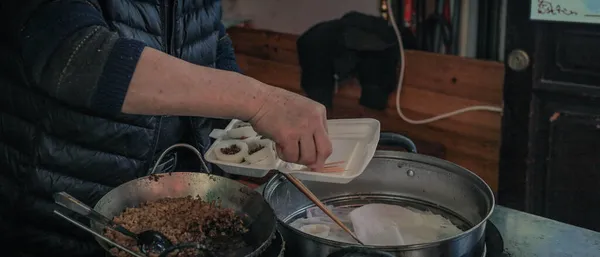 a man is cooking a food in the kitchen.