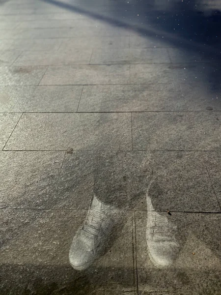 a closeup shot of a wet feet on a road