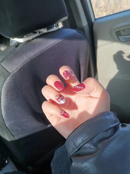 woman\'s hand with a red lipstick in the hands of a car