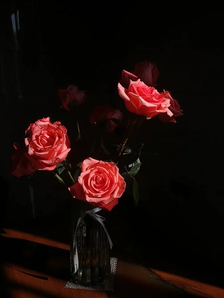 beautiful roses in a vase on a black background