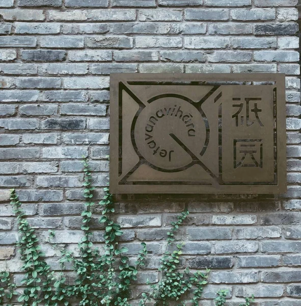 old brick wall with a sign of a house