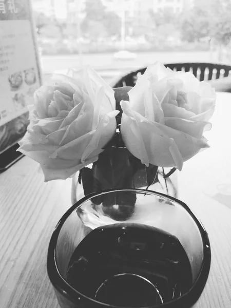 beautiful roses in a vase on a wooden table