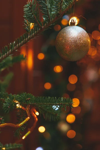 soft focus and noise pollution Christmas tree decoration of festive balls and garland lights and blurred background, holidays vertical photography
