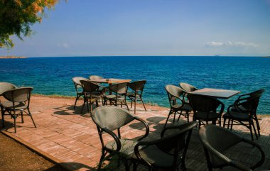 Yaz tatilinde deniz kıyısında masa ve sandalyeli boş kafe avlusu, karantina sınırlaması