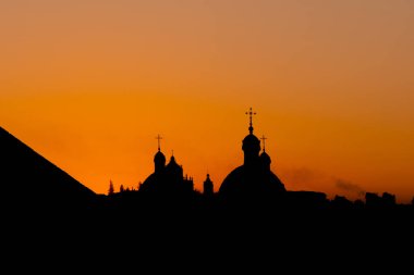 Katedral İslami Din Binası 'nın şehir silüeti akşam karanlığında dumanla ve arka planda parlak turuncu ışıkla yanıyor.