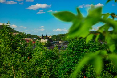 Bahar günü aydınlık ve açık hava zamanı ağaç yeşilliği ön planı ve arka plan eski bina nesneleriyle manzaralı açık hava manzarası