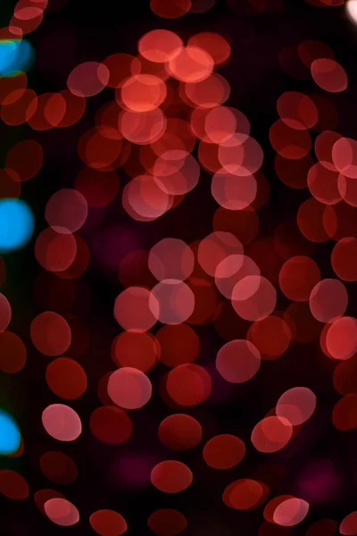 お祝いのガーランドランプからの赤光ボケ抽象効果縦画像の黒背景フォーマット — ストック写真