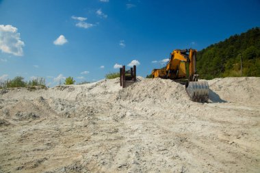 dirty industrial work with pollution of environmental space, excavator dig canal for infrastructure and make ground sandy and poor