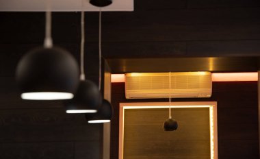 unfocused modern interior space indoor with hanging minimalist lamps with smooth dark light, crooked design style of frame and walls