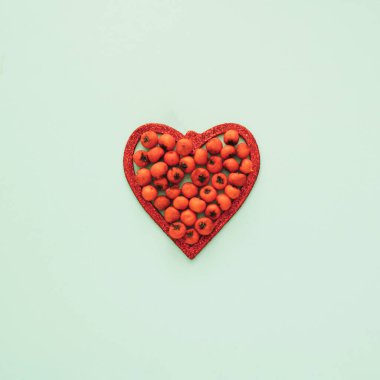 Kırmızı parlak kalp ve yeşil fonda kırmızı böğürtlen santarı