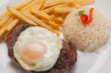 Geleneksel Brezilya yemeği. At bifteği (yumurtalı fileto pilav ve patates kızartması ile servis edilir.).