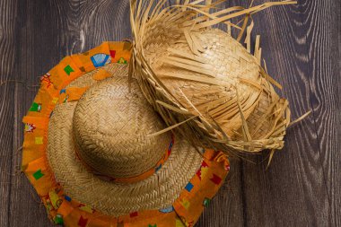 Hasır şapka haziran festivali için yukarıdan ahşap arka planda görünüyor.