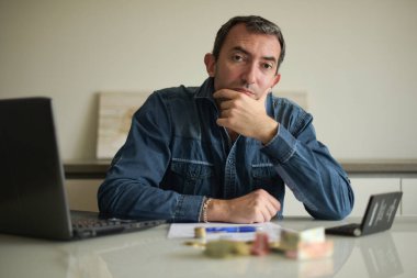 Adam evdeki faturalarını kontrol ediyor.