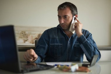 Adam evdeki faturalarını kontrol ediyor.