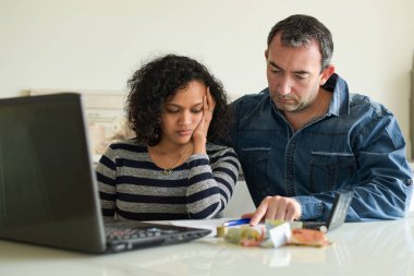 Evde tüketici faturalarını yöneten ırklar arası bir çift.