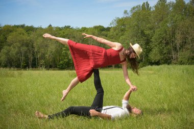 caucasian couple doing stunts on a meadow in France