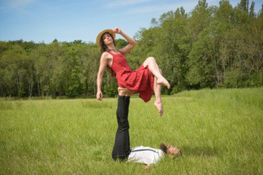 caucasian couple doing stunts on a meadow in France