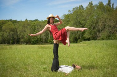 caucasian couple doing stunts on a meadow in France