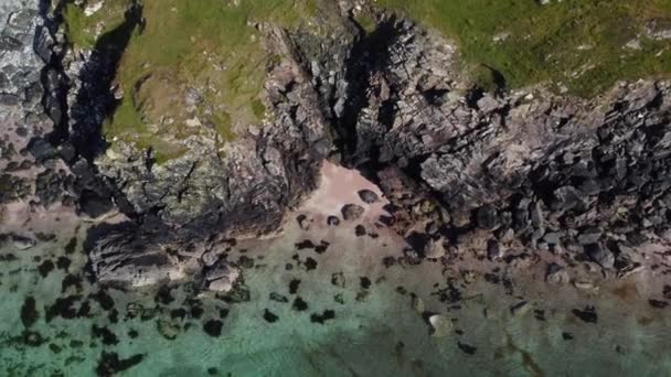 Drone вид прихованих берегових хвиль і скель серед гірського ландшафту, Шотландія — стокове відео