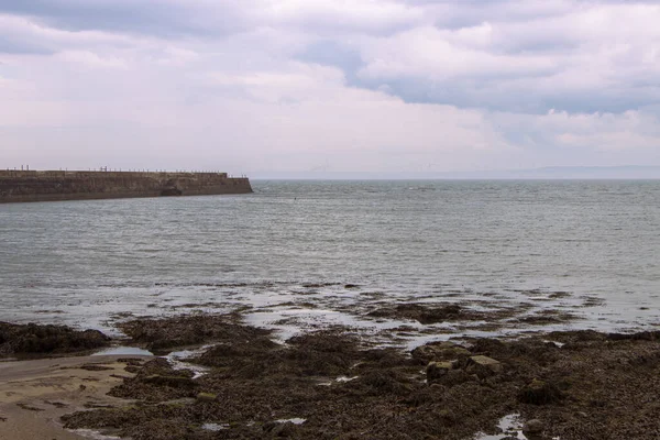 Jetée brise-lames de Heugh à partir du rivage par temps orageux et nuageux paysage marin — Photo