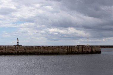 İkonik çizgili Seaham deniz feneri rıhtımda bulutlu ve deniz duvarlı