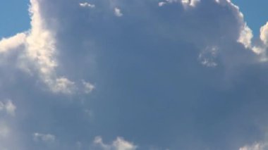 Fluffy cumulus clouds zoomed in close up and sped up in a timelapse. Footage shows dramatic clouds formation against a blue backdrop of sky