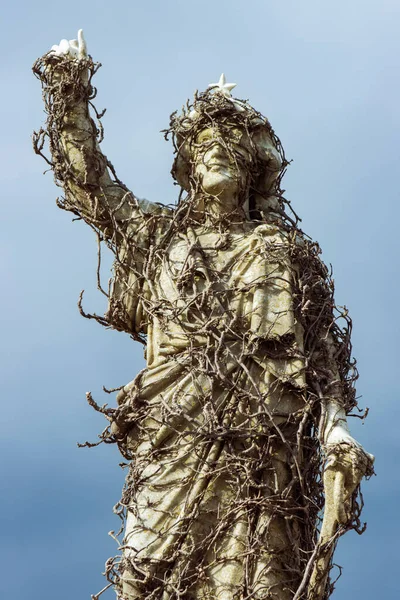 Grave statue covered in vines at Waverley Cemetery, a heritage-listed cemetery on top of the cliffs at Bronte in the eastern suburbs of Sydney, New South Wales, Australia.