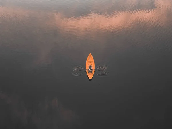 Flygfoto på en man som rodde en båt. Moln reflekterar på sjöns yta. — Stockfoto