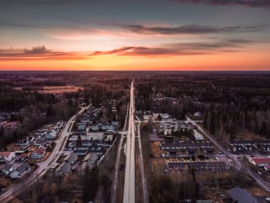 Finlandiya, Nurmijarvi, Roykka 'daki küçük bir kasabanın hava günbatımı fotoğrafı. Uzun düz cadde geçidi. Drone fotoğrafı.