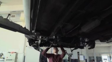 Two mechanics repair suspension car