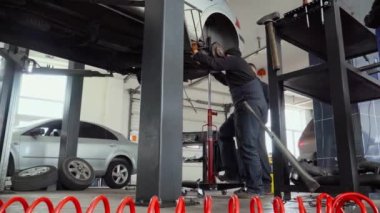 Two mechanics repair suspension car