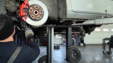 Three mechanics repair suspension car
