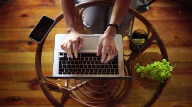 Beautiful girl typing on a laptop top view