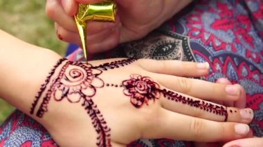 Dışarıya yakın küçük bir kızın eline mehndi çizmek.