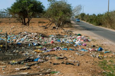 Agadir, Fas, 16 Ocak 2022: Yolun kenarındaki dağınık çöpün fotoğrafı. Atık imhası ve çevre kirliliği kavramı