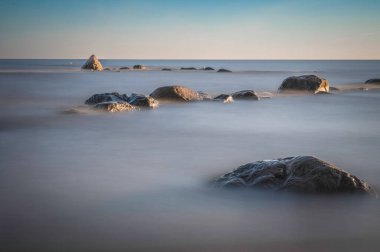Sahilde gün doğumu taşlarla.