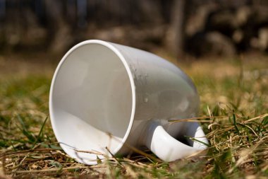 Beyaz plastik çöp tenekesi çimlerin üzerinde