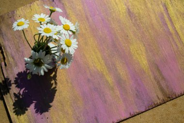 Tahta bir arka planda vazoda bir buket papatya..