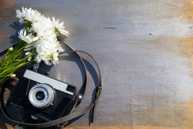 Ahşap bir arka planda çiçekli Retro kamera