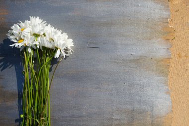 Ahşap arka plan üzerinde beyaz papatya buketi.