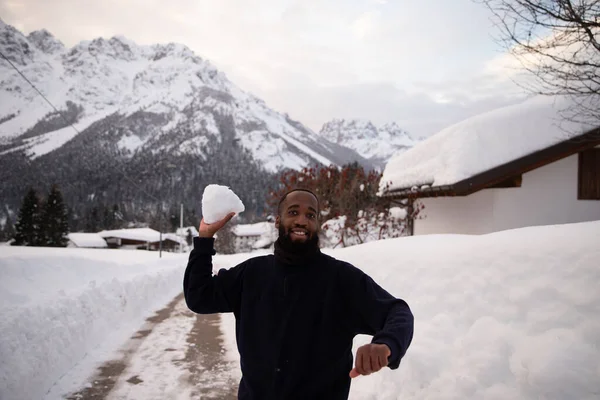 Kışın Dağlarda Yaşayan Afrikalı Bir Adam Bir Kartopu Atmak Için — Stok fotoğraf