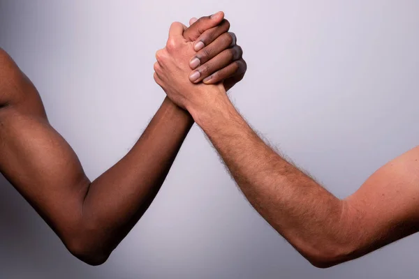 两只胳膊 一只白人高加索人 一只黑人非洲人 进行手臂摔跤 多样性的概念 种族主义 — 图库照片
