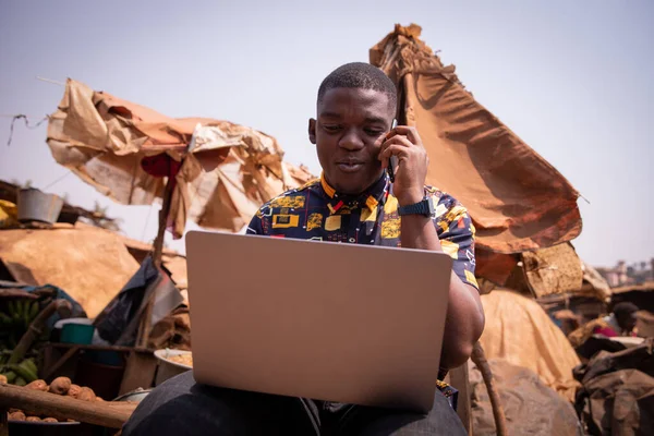 Młody Afrykanin Pracuje Laptopem Wykonuje Telefon Jest Rynku — Zdjęcie stockowe