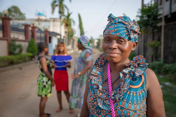 Arka planda konuşan üç kadınla izole bir Afrikalı kadının portresi, Afrikalı kadın konsepti.