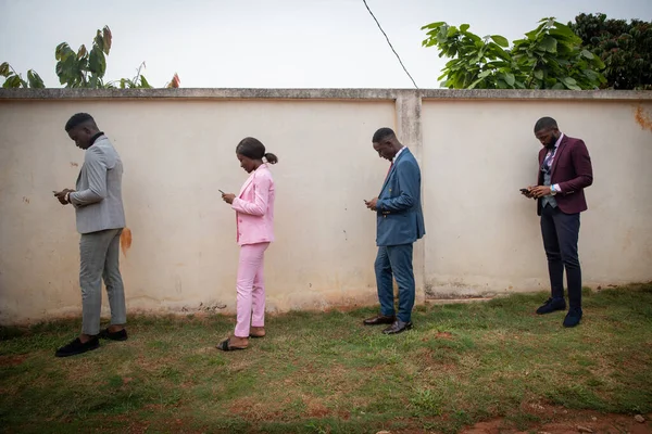Grupa Dobrze Ubranych Młodych Afrykanów Używa Smartfonów Kolejce Zachowując Bezpieczną — Zdjęcie stockowe
