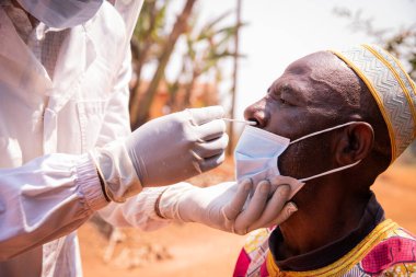 Afrikalı son sınıf öğrencisi, Afrika 'da burnuna, sağlığına ve ilacına yerleştirilmiş bir bezle koronavirüs testi yaptırıyor.
