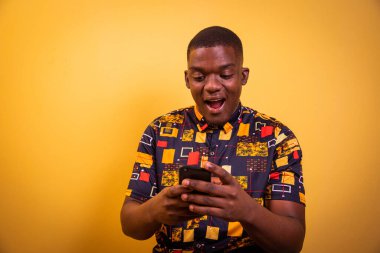 Afrikalı çocuk akıllı telefonunu kullanıyor ve ekrana bakarken şaşırıyor.