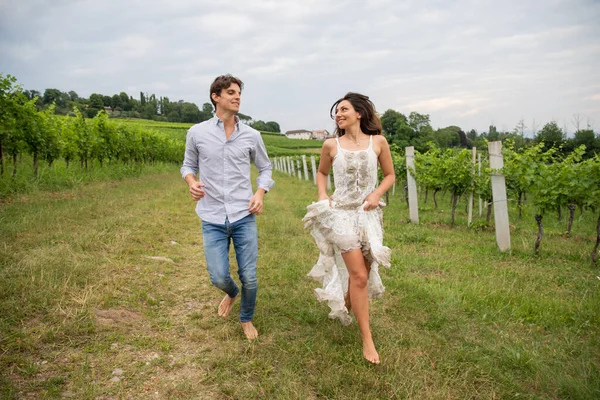 Genç çift kırsalın ortasındaki üzüm bağında koşmaktan hoşlanıyor..