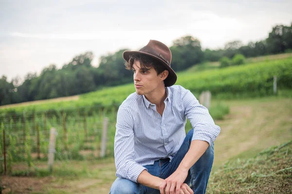 Boy wearing a country hat on vacation visits vineyards where he gets beautiful photo shoots.