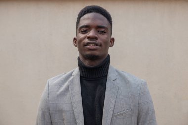 Zarif giyimli, izole edilmiş ve kameraya bakan Afrikalı bir çocuğun portresi.